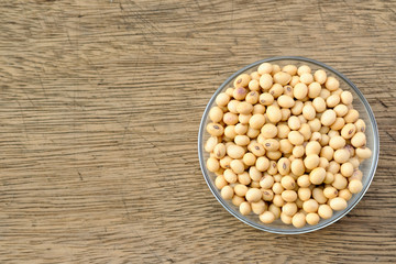 Soybeans are in a cup, placed on a wooden table with copy space