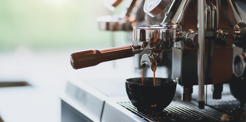 Close-up view of espresso pouring from espresso coffee machine into a coffee cup - Powered by Adobe