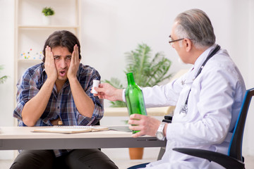 Young male alcoholic visiting old doctor