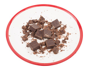 Broken chocolate on plate on white background