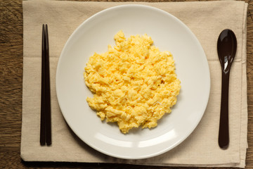 Scramble on a white plate with spoon and chopsticks,copy space