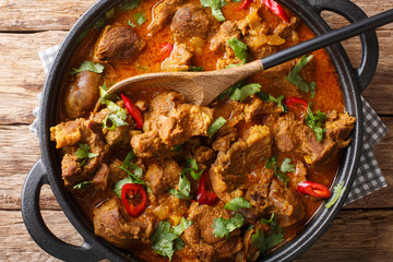Indian traditional food Lamb rogan josh close-up in a pan. Horizontal top view
