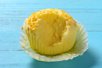 mango or orange flavor cup cakes with a bite on a blue wood table