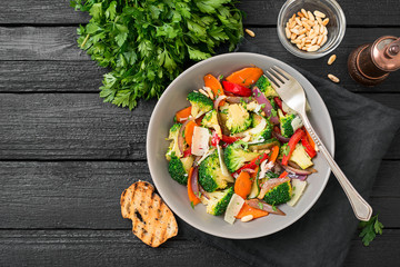 Healthy warm broccoli salad with parmesan cheese and pine nuts.