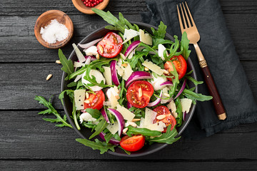 Fresh arugula salad with pine nuts, cherry tomatoes and parmesan cheese.