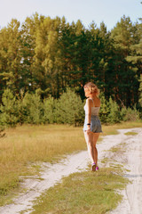 Beautiful teenager girl on a walk in the summer forest. The concept of happiness, hope for the future and the beauty of nature