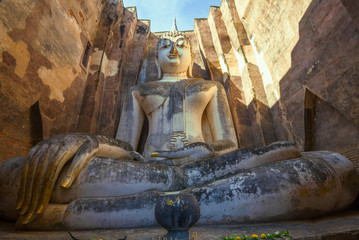 Giant statue of a sitting Buddha (Phra Achana) close-up. The ruins of the ancient Buddhist temple Wat Si Chum. Sukhothai, Thailand