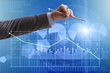 Businessman controlling the market with strings
