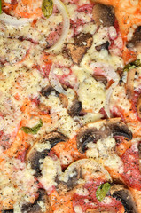 Fresh baked homemade pizza with mushrooms, onions, Gouda cheese, basil, oregano and tomato sauce. Macro. Vertical photo.