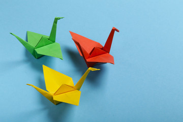 origami paper crane on a blue background - obrazy, fototapety, plakaty