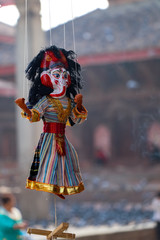 Puppets in traditional Nepali dresses hanging by a thread
