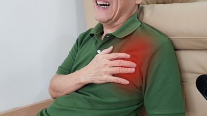 Old man has chest pain and painful facial expression. Chest pain symptom may be from medical emergency heart disease as angina, myocardial infarction, acute coronary syndrome, pericarditis disorder.
