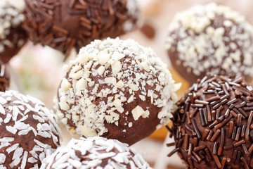 Chocolate cake pops decorated with nuts and shredded desiccated coconut.