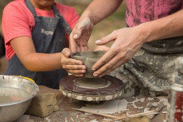 close-up of a Potter's hand sculpts a pot pitcher of clay on a Potter's wheel