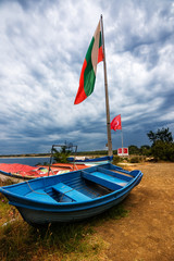 Fototapeta premium Emigration boat and Turkish and Bulgarian flag on the border of Bulgaria and Europe in Rezovo