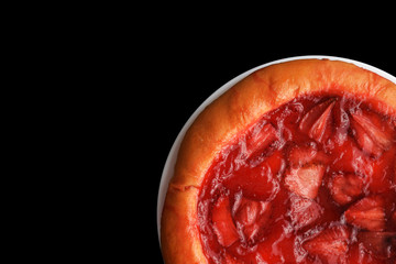 Strawberry pie on a white plate isolated on black background. Yeast pie with strawberry jam and pieces of berries. Flat lay. Copy space	