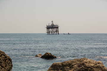 Abandoned oceanographic platform near Black Sea coast, Crimea. Old abandoned sea rusty drilling platform.