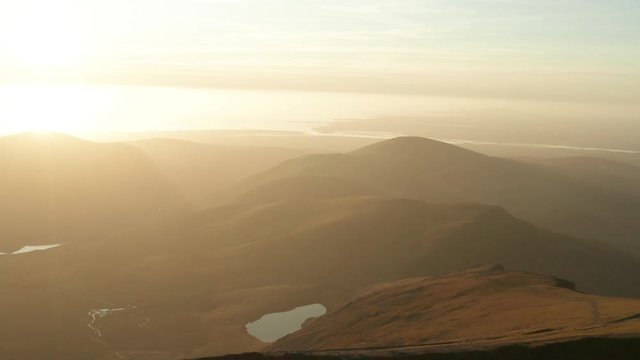 Snowdonia sunset background aerial with glare and mountains glowing