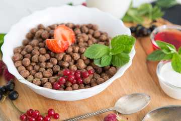 breakfast Healthy tasty breakfast chocolate balls with strawberries, raspberries, black currants and red currants.