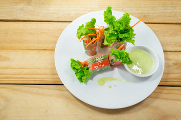 Fresh vegetable salad rolls in a tube noodles on a plate Placed on a wooden background.