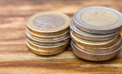 Two stack of euro coins on wooden table. Close up.