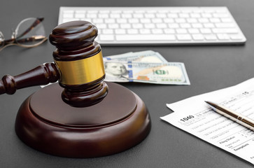 Obraz na płótnie Canvas Judge's gavel with tax form, money and computer keyboard on black office desk.