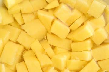 Sliced peeled raw potato in the water. Top view. Food background