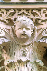 Detail of a tomb column on a graveyard- sculptured head of a little boy