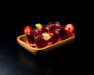 Shots of alcohol topped with various fruits