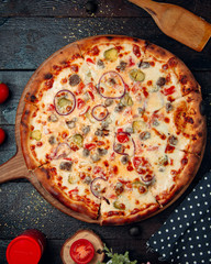 Mixed pizza topped with onion and mushrooms
