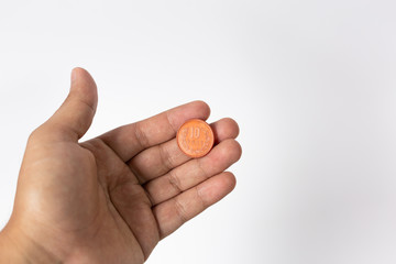 hand holding a coin isolated on white background