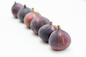 line of fresh figs on a white background