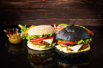 Delicious fast food. Delicious hamburgers on wooden background