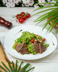 Meat slices with vegetables topped with sesame