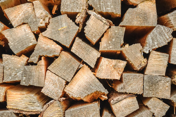 An array of firewood for burning in a stove is piled close-up.