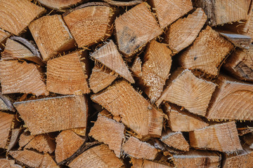 An array of firewood for burning in a stove is piled close-up.