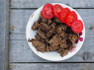 minced meat with tomato in a plate on a wooden background