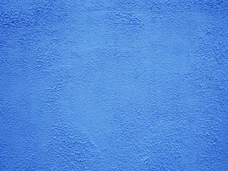 Fototapeta na wymiar Wall covered by sprayed plaster and painted in blue color. Exterior of a building. Closeup