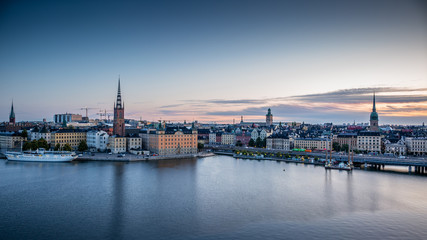 A colorful sunrise over Stockholm with the lights reflecting on the calm water of the sea - 8