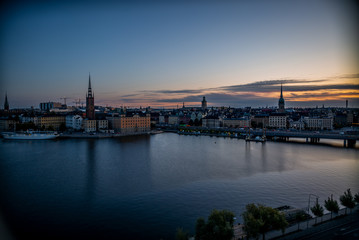 A colorful sunrise over Stockholm with the lights reflecting on the calm water of the sea - 9