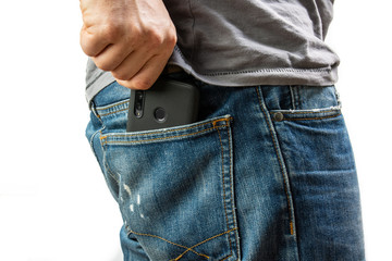 A man pulls a smartphone out of the back pocket of his jeans
