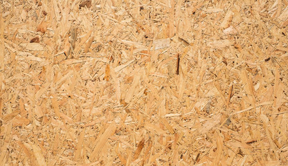 OSB boards are made of brown wood chips sanded into a wooden background. Top view of OSB wood...