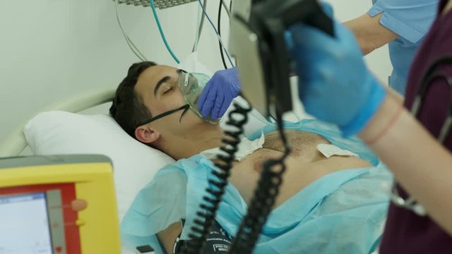 Doctors give resuscitation to a male patient in the emergency room. Cardiac mass