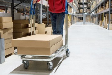 Man pushing trolley with boxes in furniture store
