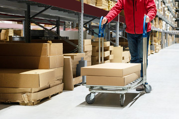 Man pushing trolley with boxes in furniture store