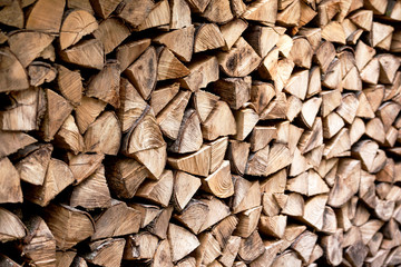 Background of dry chopped firewood logs in a stack
