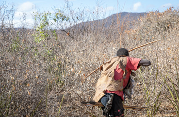 hadzabe man with his bow and arrow hunting for birds