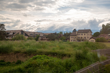 Fototapeta premium Beautiful scene of houses in rural area of switzerland on cloud sky with sunlight background and copy space