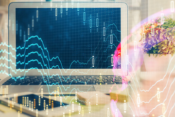 Forex market graph hologram and personal computer on background. Multi exposure. Concept of investment.