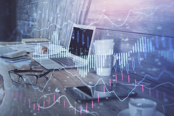Forex market graph hologram and personal computer on background. Multi exposure. Concept of investment.